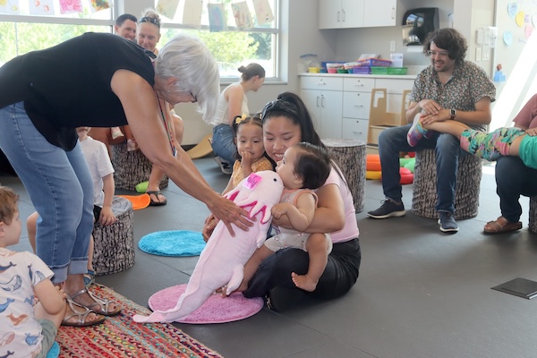 Mom and daughters interacting with bilingual storytime leader at Pinney Library